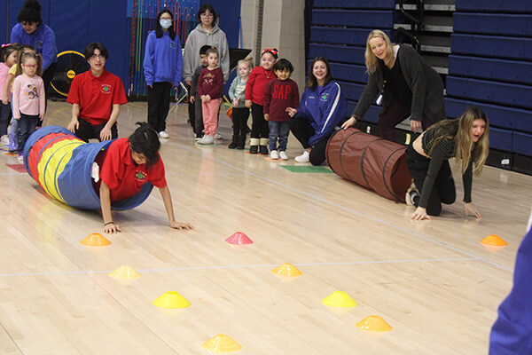 students participating with children in gym