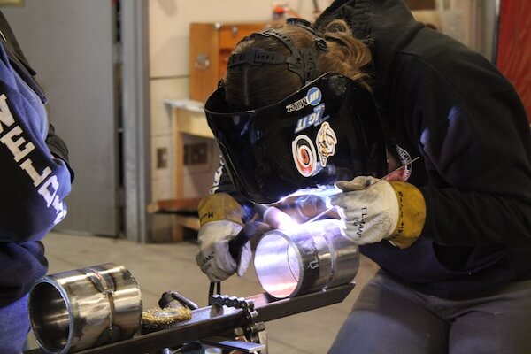 A Welding student welding metal.
